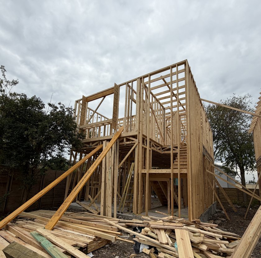 A two-storey backyard unit under construction, framing exposed